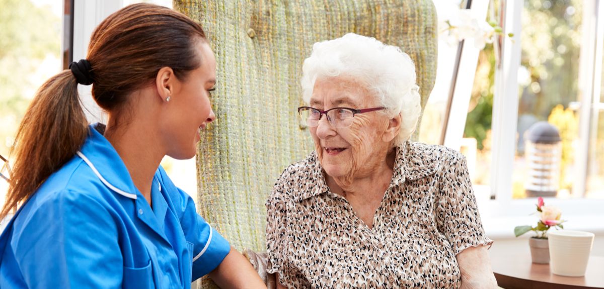 Care worker helping an elderly woman